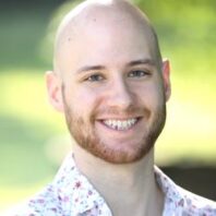 Tightly cropped head shot of Philip outside on a sunny day.