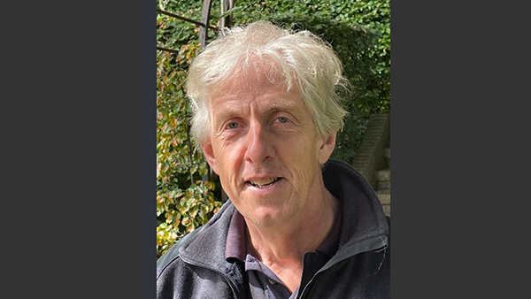 Jon with greenery behind him.