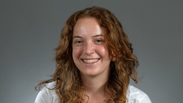 Chloe in a photo studio. Her hair is long, red, and curly.