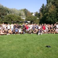 Large group of JSA members posing for a picture in an open field on a sunny day.