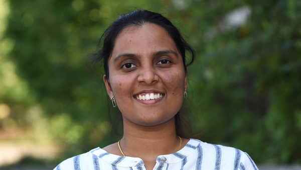 Anoli outside with greenery behind her.