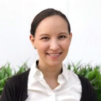 Lisa Vrooman, wearing a white button up top and black sweater.