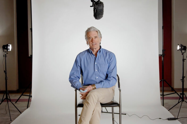 A seated person in a blue collared shirt.