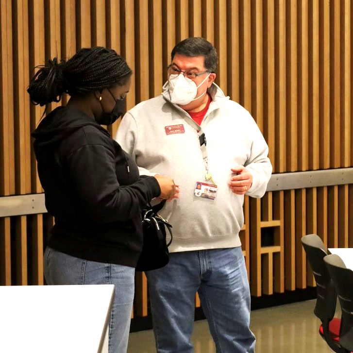 Two people standing and talking.