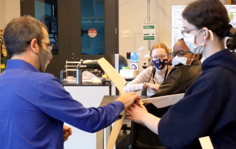 Two people conferring over a propeller.