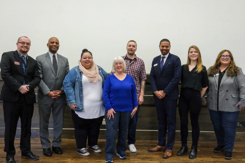 Eight people lined up for a group portrait.