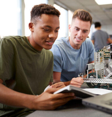Two people looking at a notebook.