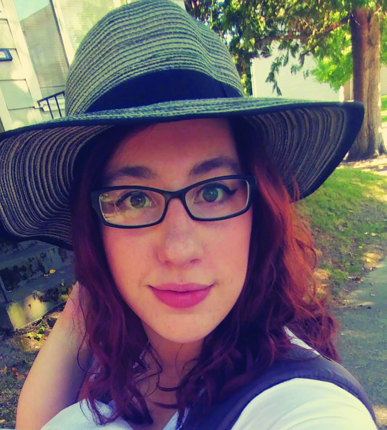Nichole Bascue wearing glasses and a green wide-brimmed hat.
