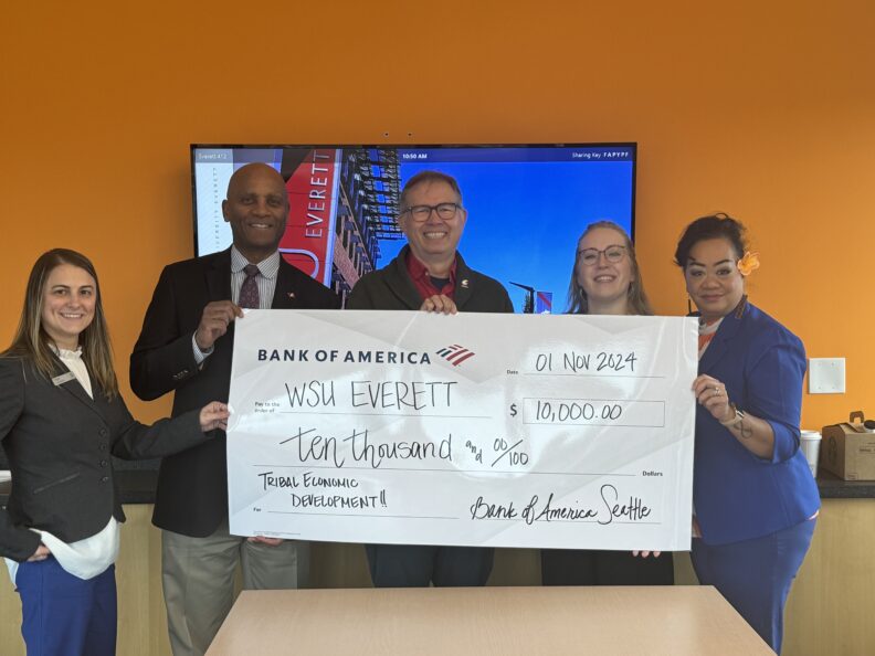 Joe Gladstone, Hayley Statema, and others holding symbolic check