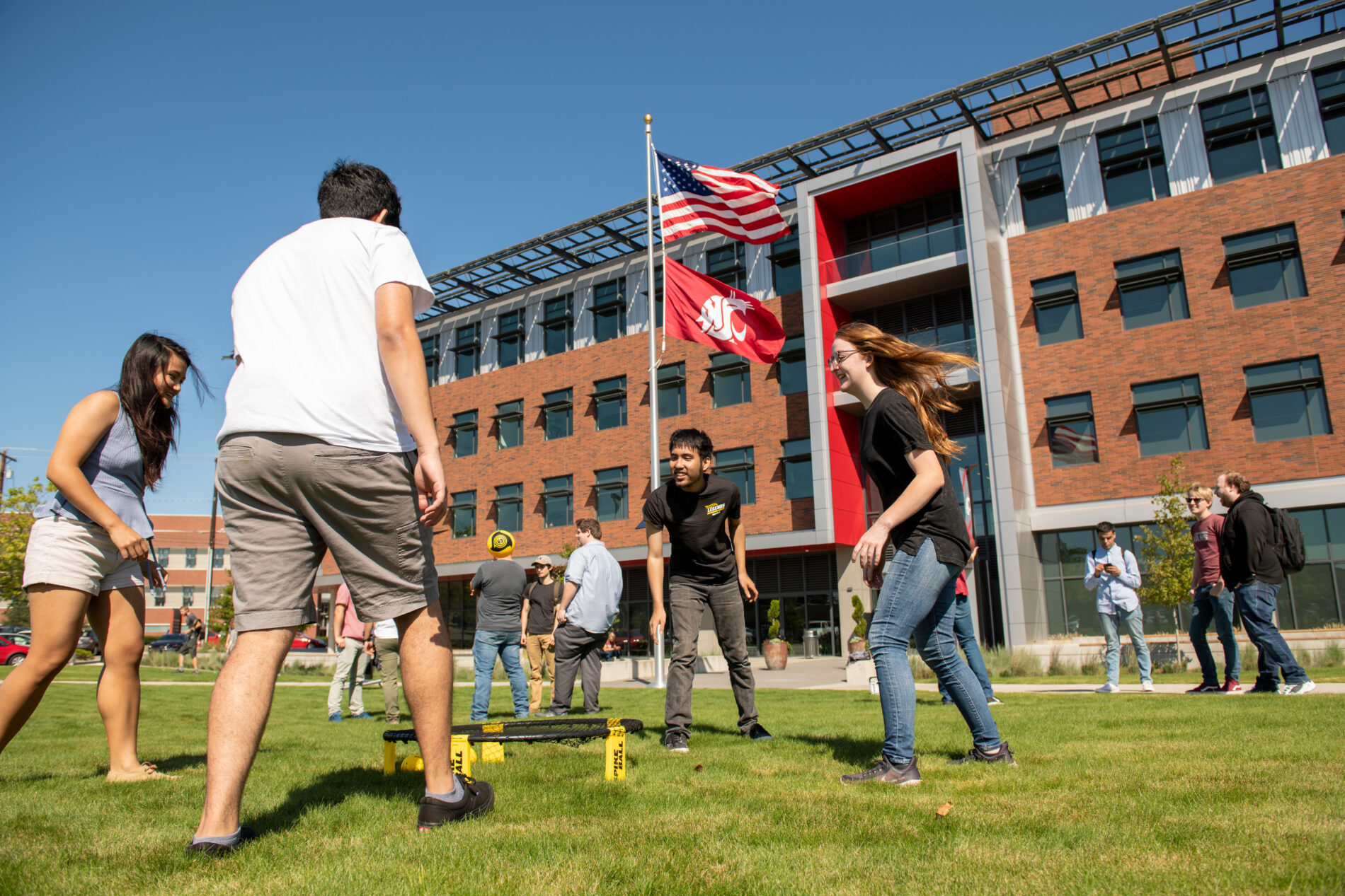Students playing in front of an academic building.