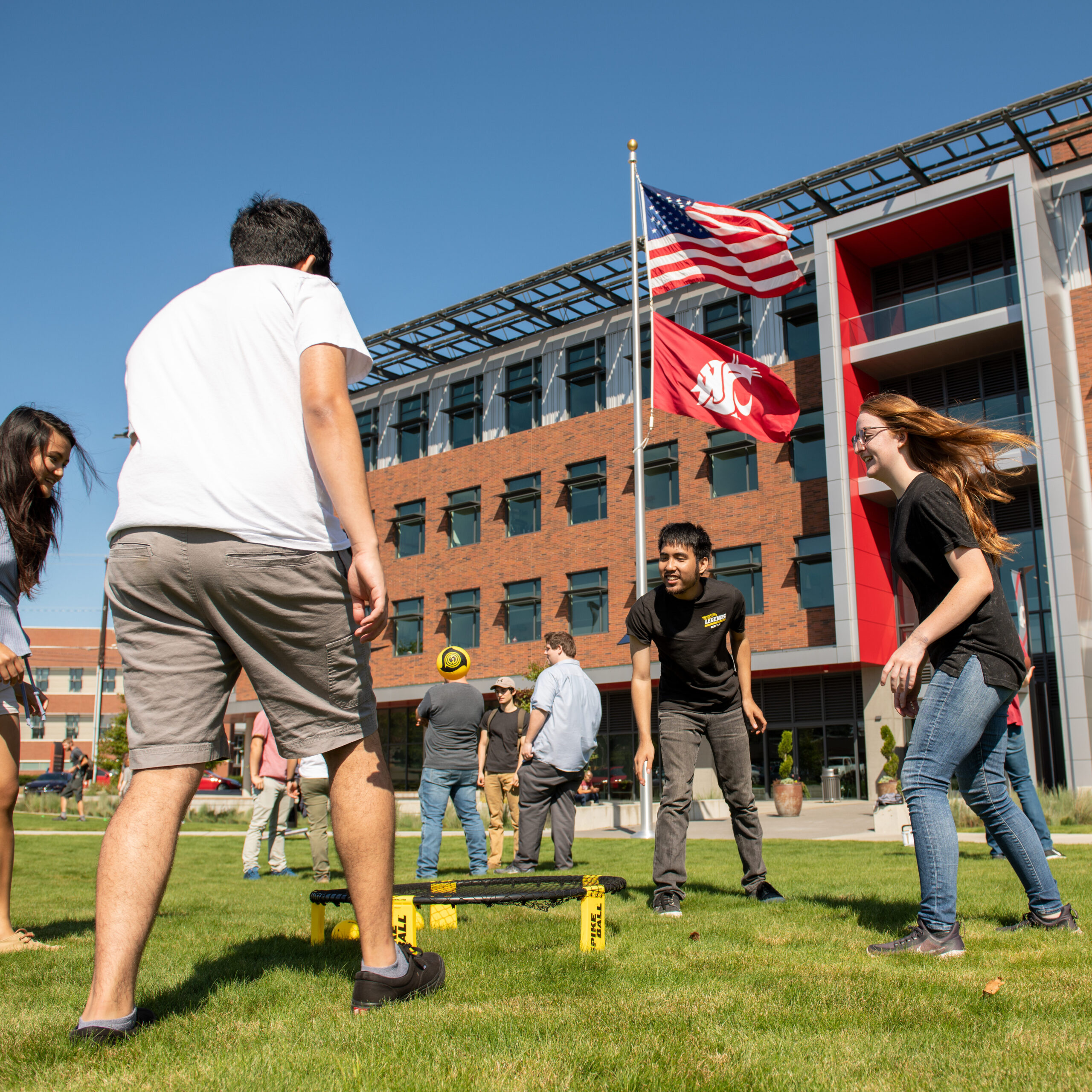 Students playing spikeball on front campus lawn