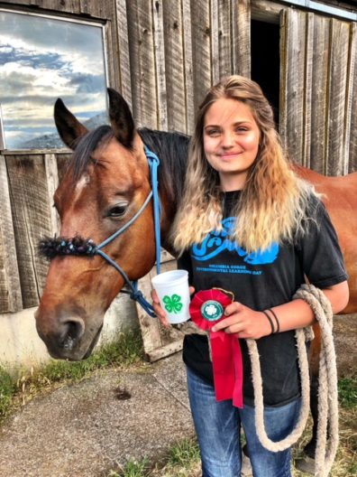 4-H member holding ribbons