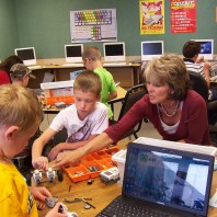 Teacher helping students with robotics