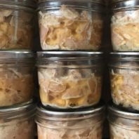 Rows of home-canned tuna in half pint jars