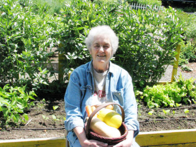 Master Gardener holding a basket of squash