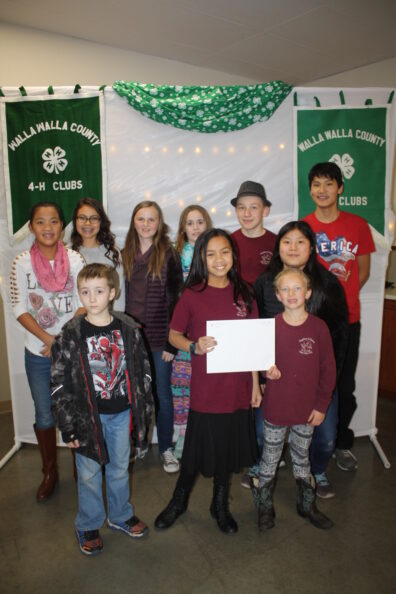 Group of 4-H youth pose for picture holding certificate of achievement.