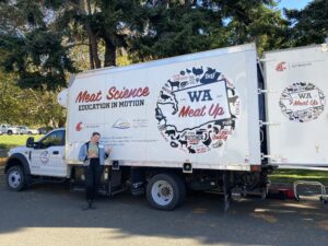 photo of mobile meat truck with person standing next to it