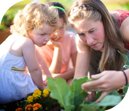 children and adult working in garden