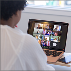 Sitting woman using laptop in an online conference
