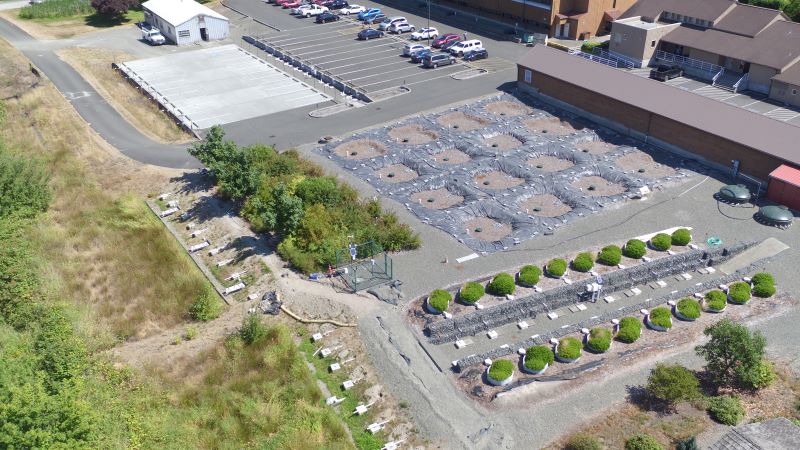 Aerial view of part of the WSU Puyallup campus. The mesocosms (lower R), 16 replica rain gardens (Center), permeable pavement parking area (upper L). Photo J. Berg.</em>
