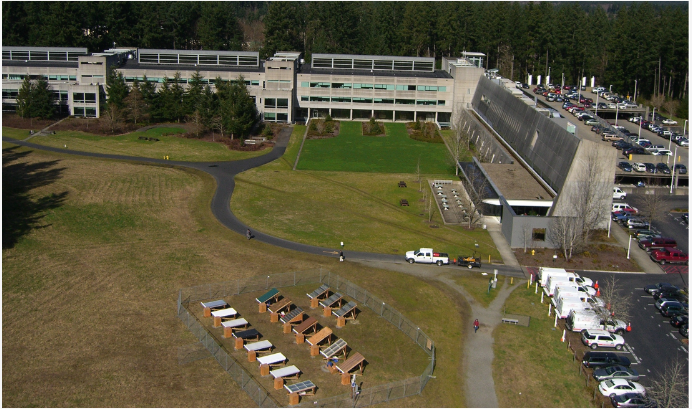 Aerial view of buildings with 14 roofing panels in center.