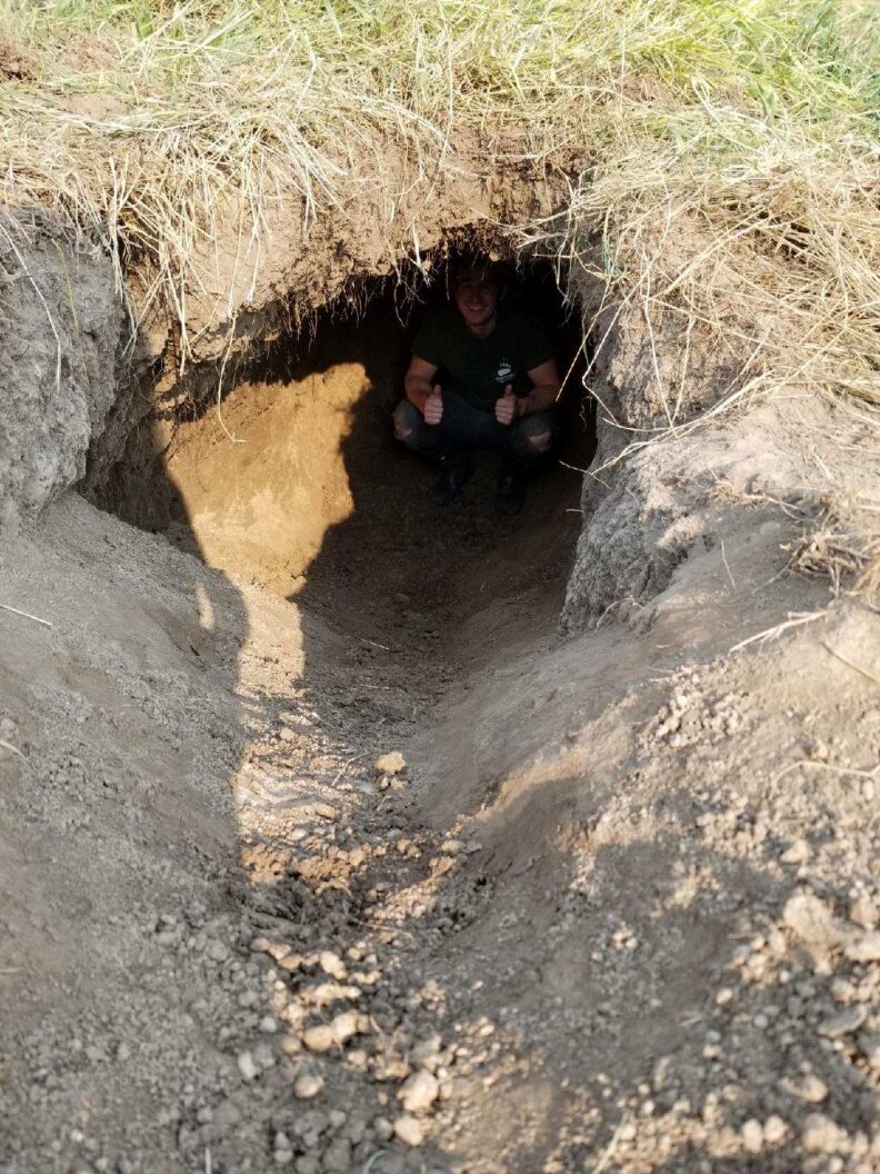 someone squatting in a bear den under the ground.