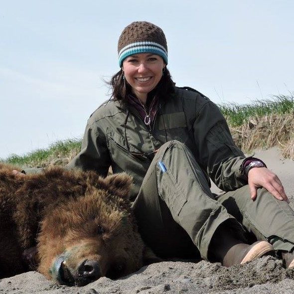Joy Erlenbach sitting next to a drugged bear.