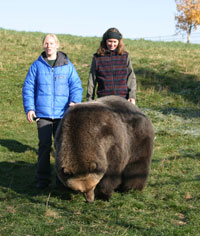 Lynn Nelson and student Jen Fortin standing with bear in yard.