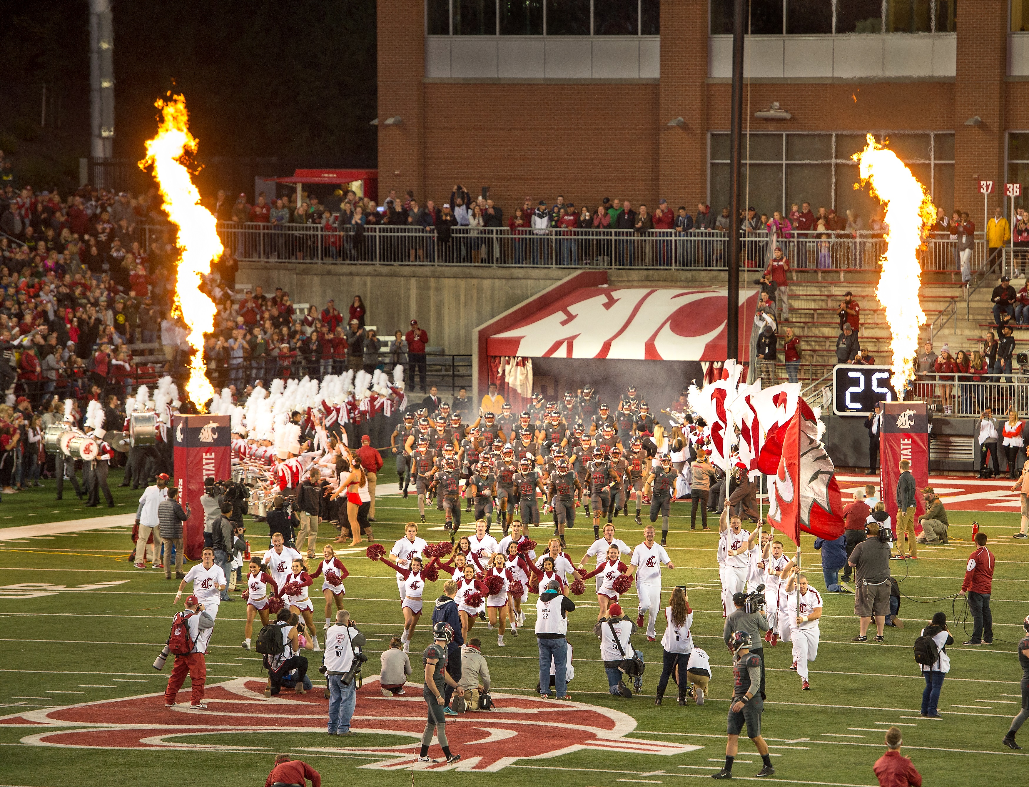 Evening image of the WSU Cougar football team running out of the tunnel onto the field at Martin Stadium/Gesa Field.