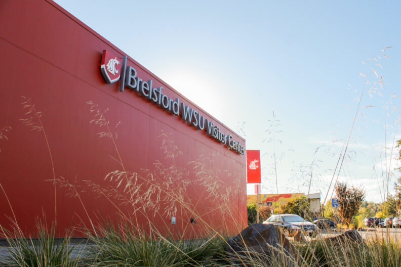 An image of the exterior back wall and name plaque of the Brelsford Washington State University Visitor Center in Pullman, Washington.