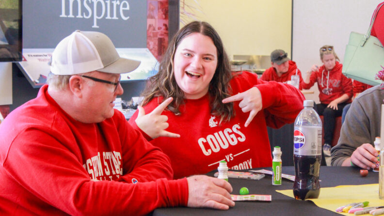 An image of an individual attending an event at the Brelsford Washington State University Visitor Center excitedly posing for the camera.
