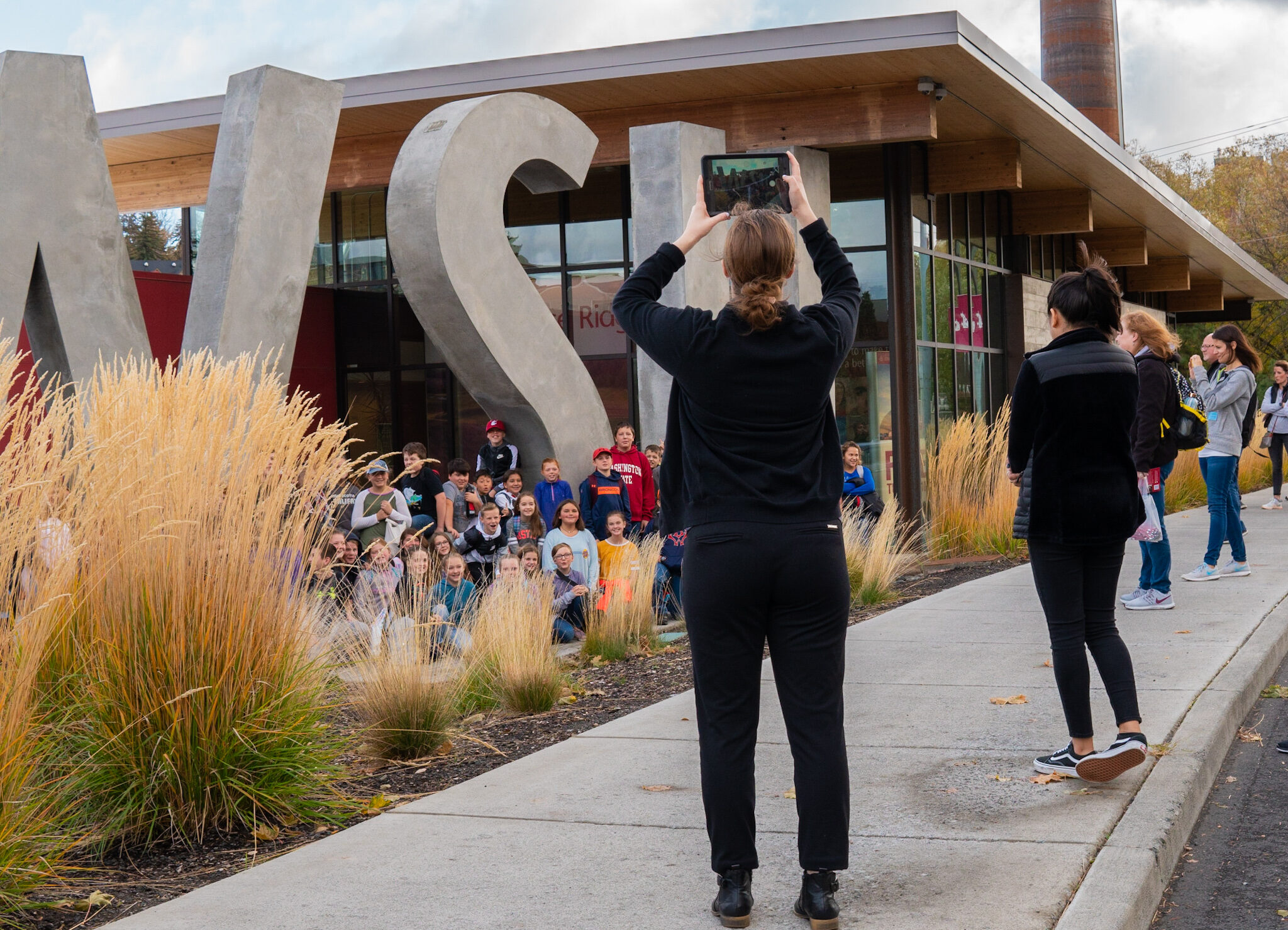 Kids posing for a group photo in front of the WSU concrete letters at the WSU Visitor Center.