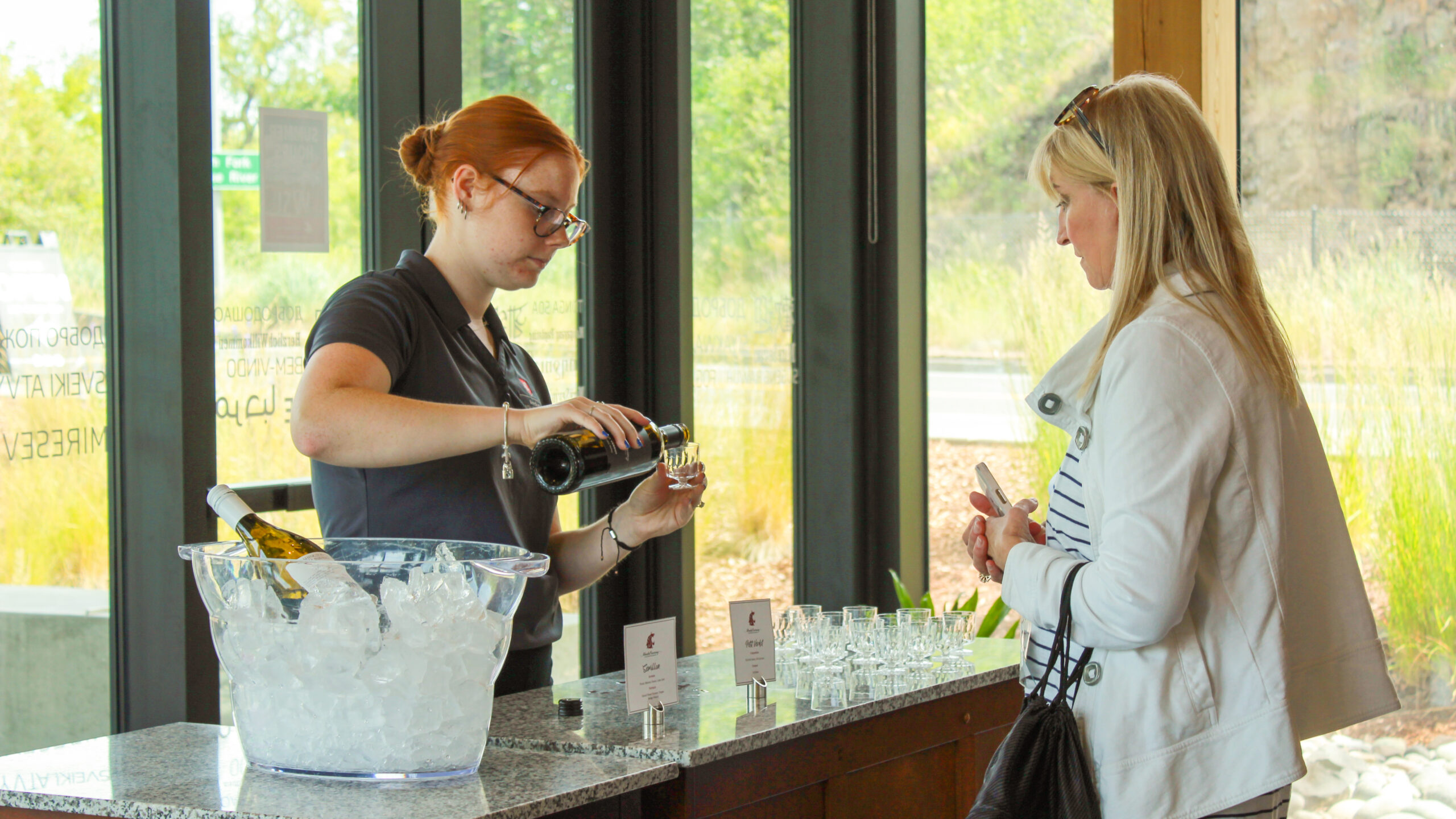 Visitor at a wine tasting event, being served a sample pour.