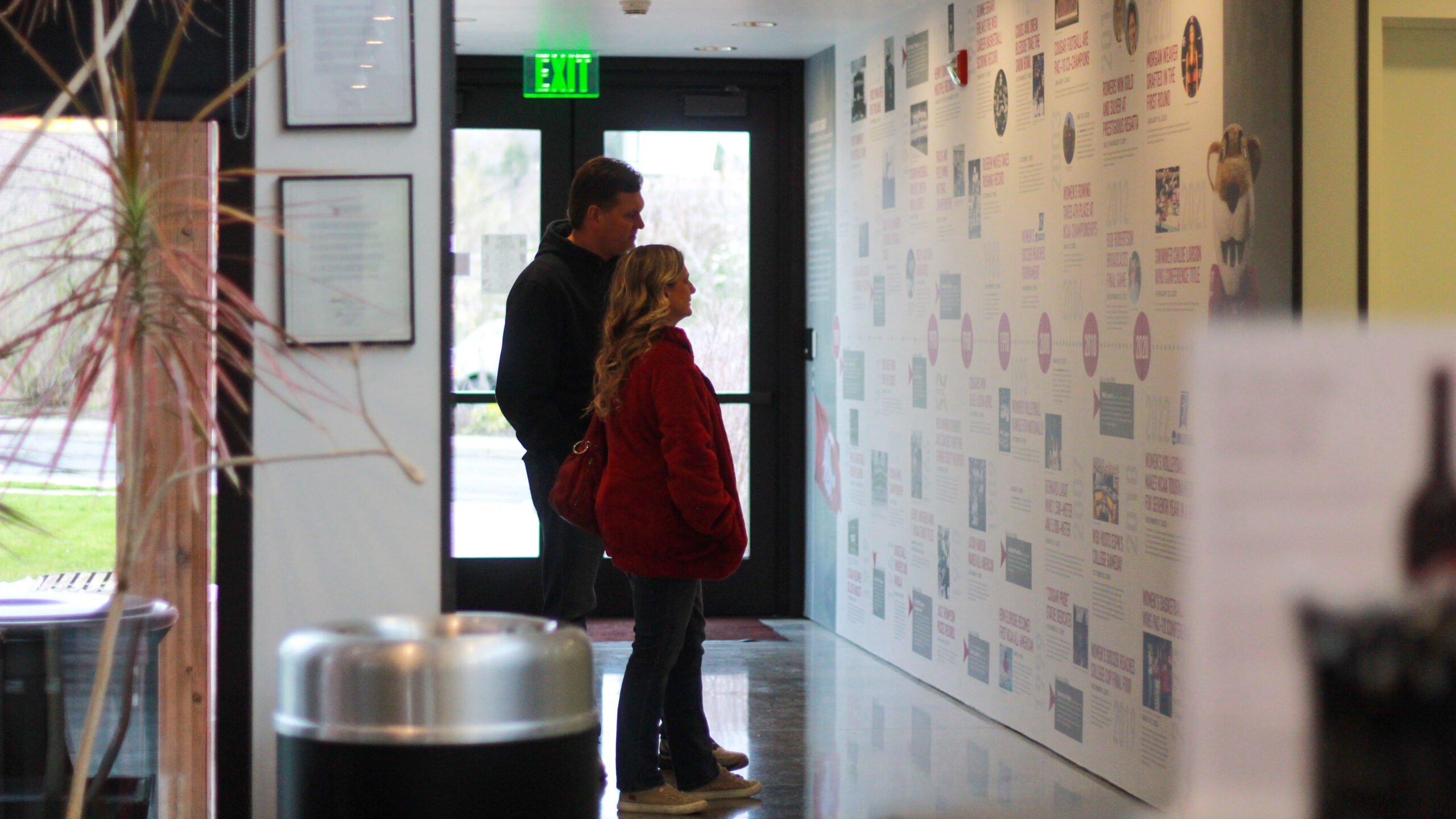 An image of a pair of visitors looking at a historical timeline inside the Brelsford WSU Visitor Center in Pullman, Washington.