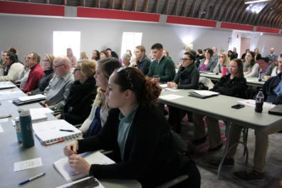 Workday trainers meet together for Train-the-Trainer kickoff in a large conference room.