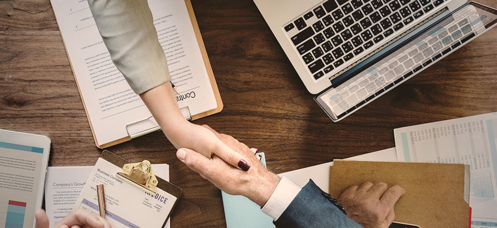 Stock image showing a business deal handshake between a two people