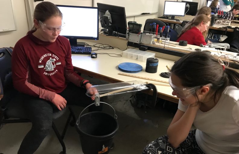 Image of two students using a beam to acquire information about materials properties.