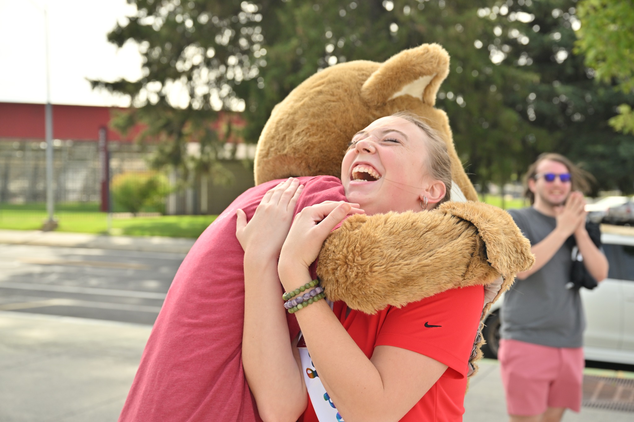 A WSU student hugs the mascot, Butch T. Cougar outdoors in the summer.