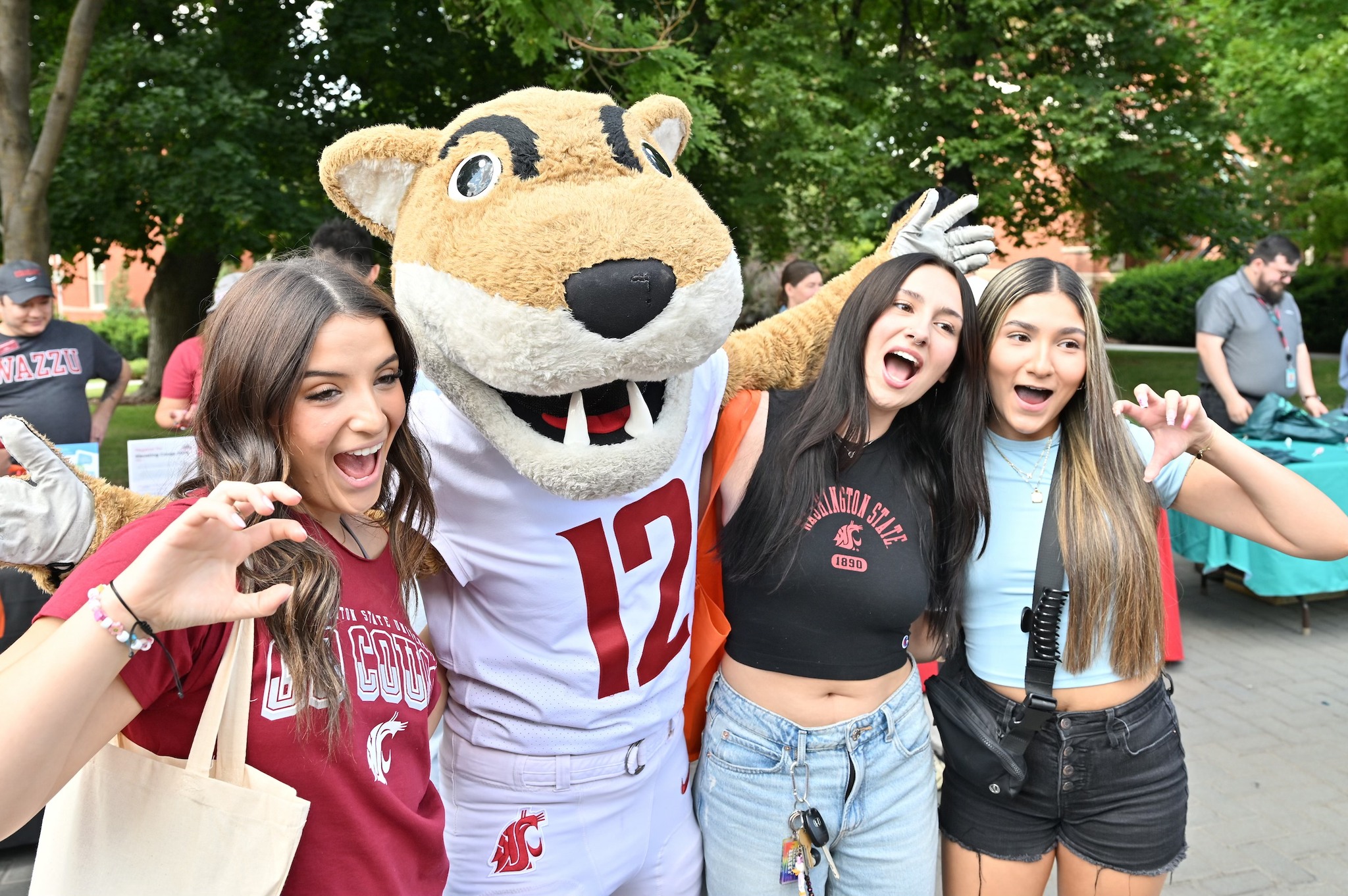Three students pose with Butch T. Cougar outside.