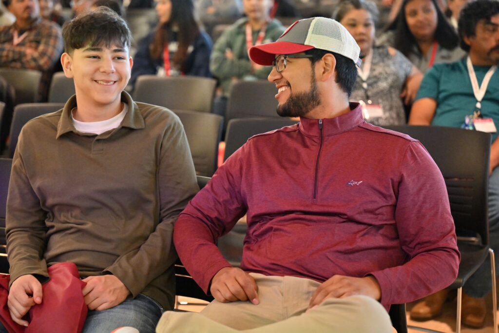 Two WSU students attend a lecture in a large lecture hall.