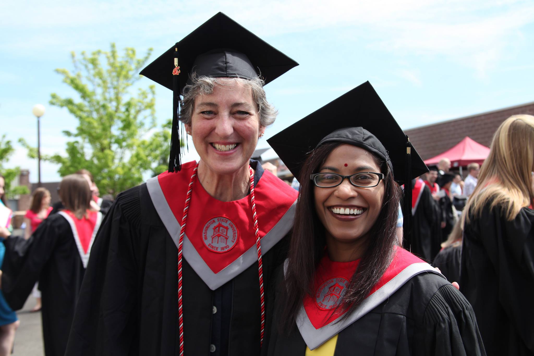 Two students pose for graduation.