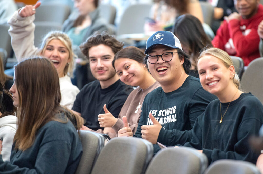 Students smiling and waving during their kinesiology class.