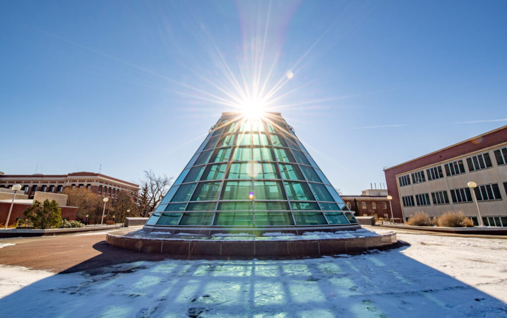 Snow and sun shining behind the Terrell Dome on top of the WSU library.