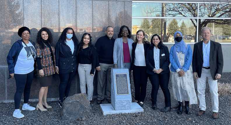 Leonard and Vanessa Moore (center), Chancellor Sandra Haynes (right of Vanessa), members of AACCES, students, and Professor Robert Bauman (far right) stand by monument plaque at WSU Tri-Cities, honoring George Washington Bush and William Owen Bush