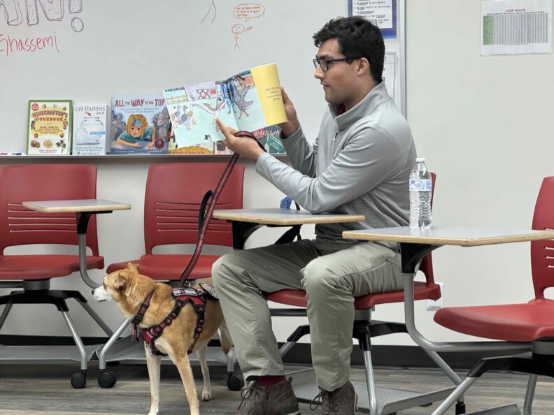 Arshan Ghassemi reads from his book Duck Duck to members of the ROAR community while seated next to his dog Luna.