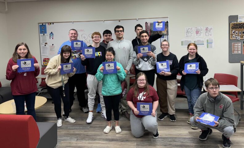 Arshan and members of the ROAR Community posing with copies of Duck Duck
