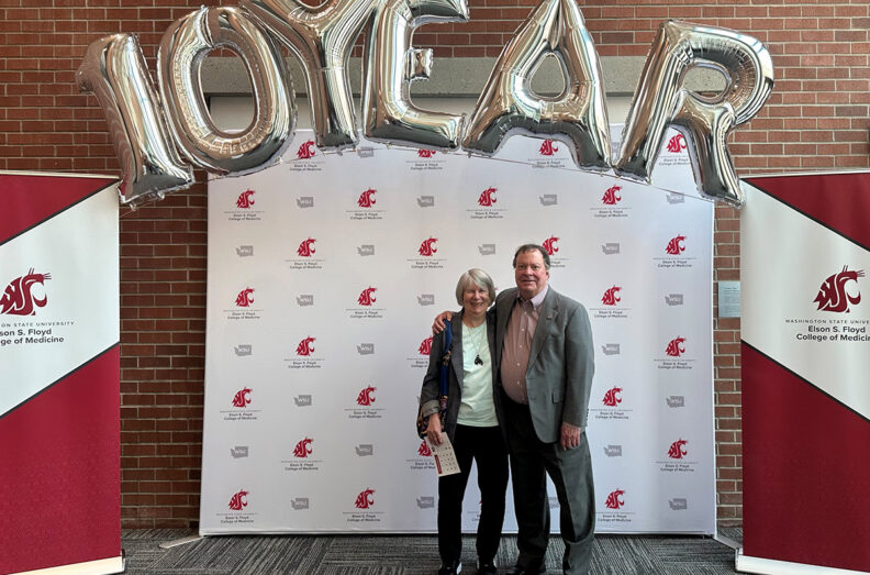 Barbara and Tom Wilson of Seattle pose in front of a WSU Elson S. Floyd College of Medicine step-and-repeat banner at the college's 10-year anniversary celebration in Spokane, April 2025.