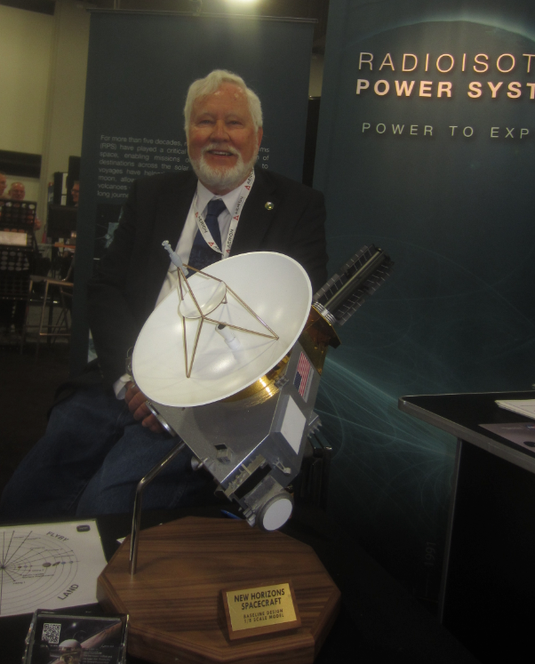 Gary Bennett at a conference next to a model of the New Horizons spacecraft, which flew past Pluto.
