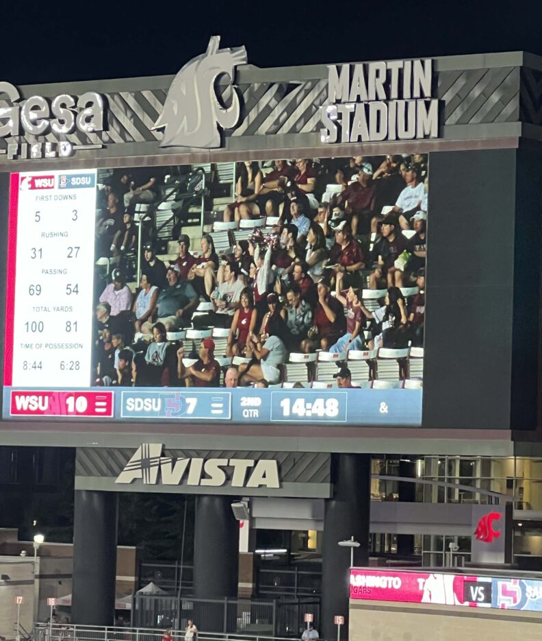 Fans appear on the video board during WSU Homecoming weekend, when David Hawthorne was recognized for his five decades of consecutive Homecoming attendance.