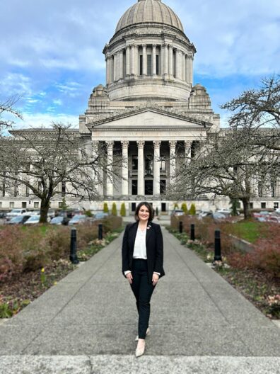 Washington State University Global Campus student leader, Alexiis McLean, standing in front of the Washington State Capitol building during Coug Day.